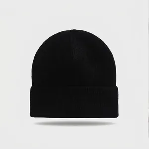 Detailed macro view of black ribbed knit beanie hat with classic folded brim for winter warmth