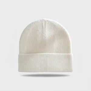 Detailed macro view of a white cuffed knit beanie with ribbed texture for winter warmth.
