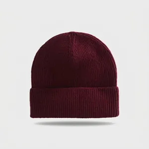 Close-up detail of a soft burgundy ribbed knit beanie showing the folded cuff