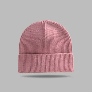 Close-up shot of a cozy pink knitted beanie hat with a classic cuffed design for winter