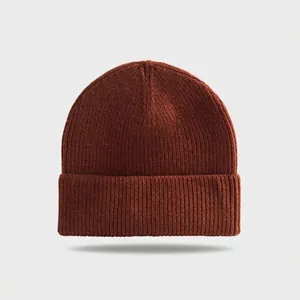 Macro detail view of a dark brown ribbed knit beanie featuring a classic cuffed design.