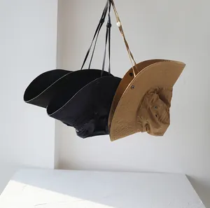 Detailansicht von schnelltrocknenden Fischerhüten mit breiter Krempe an der Wand.