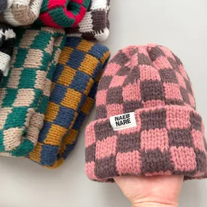Close-up detail of thick checkered knit beanies showing texture and multiple colors