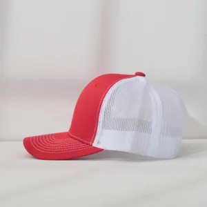 Detailed side view of a red and white mesh trucker cap featuring precise brim stitching