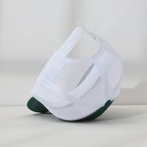 Detail view of the breathable white mesh and adjustable snapback on the green trucker hat