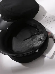 Close-up detail of the inner lining and texture of a black classic baker boy hat