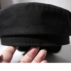 Detail shot of the textured black fabric on a flat-top newsboy sailor hat