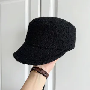 Close-up view of black textured woolly military cap showing thick bouclé fabric details.