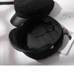 Detailed view of black classic fiddler cap showing interior lining and leather brim texture.