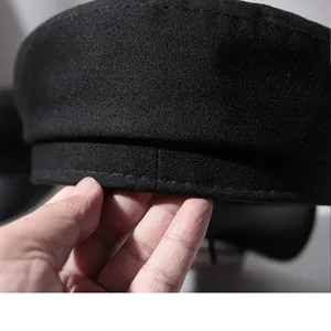 Close-up of the premium black fabric texture and fine stitching on a classic newsboy hat.