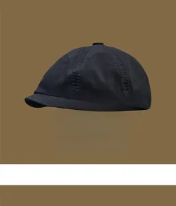 Close-up detail of a vintage black cotton newsboy cap with premium visible stitching
