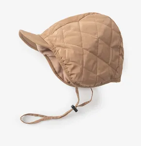 Detailansicht der braunen gesteppten Wintermütze mit warmem Fleecefutter und verstellbarem Riemen