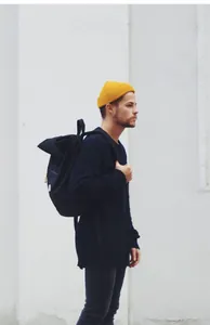 Profilo laterale di un uomo che indossa un berretto in maglia a coste giallo brillante.