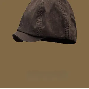 Close-up detail of a retro brown washed canvas beret hat with classic stitching texture