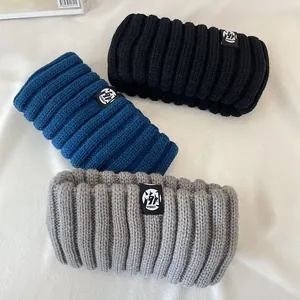 Macro view of three thick knitted winter headbands in black, blue and grey textures