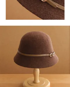 Gros plan d'un chapeau cloche en laine marron rétro avec boucle de ceinture élégante