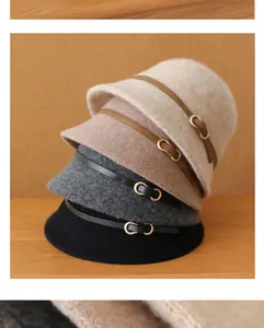 Détail montrant une pile de chapeaux cloche en laine dans des tons neutres élégants