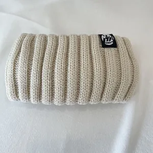 Detailed view of the thick beige ribbed knit texture on this warm winter headband.