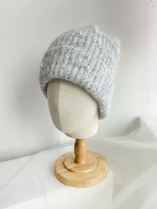Detailed macro view showing the soft texture and pearl accents on this grey knitted beanie
