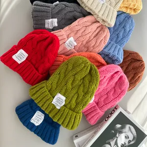 Varietà di berretti colorati in maglia a trecce con etichette bianche per l'inverno