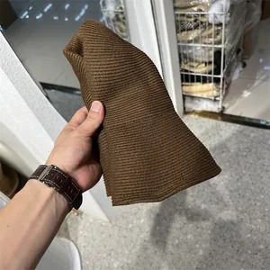 Detailed macro view showing the brown woven texture and foldable design of a straw hat