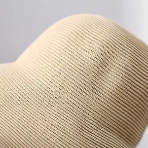 Close-up macro detail of the high-quality fine straw weave on a beige summer sun hat