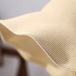 Macro view showing the intricate woven texture and stitched edge of a beige straw sun hat brim.
