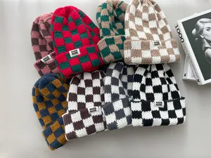 Close-up detail of stylish thick checkered knit beanies in multiple colors for winter