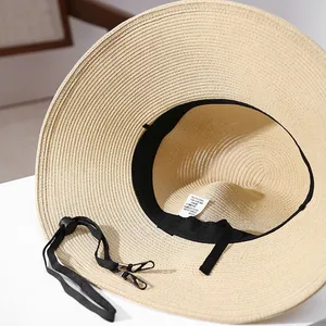 Detail view of wide brim straw sun hat showing inner sweatband and adjustable chin strap.