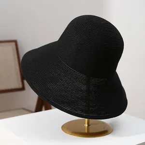 Detailed macro view of a premium black foldable straw sun hat with a large brim