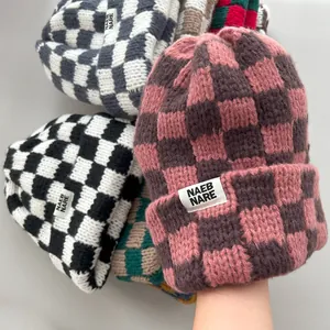 Thick knitted beanies with checkerboard pattern showing soft texture and warm colors
