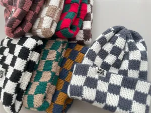 Detailed view of various colorful checkered thick knit beanies for autumn and winter
