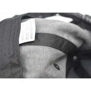 Detalle del material 100% algodón y la etiqueta de cuidado de la gorra de béisbol