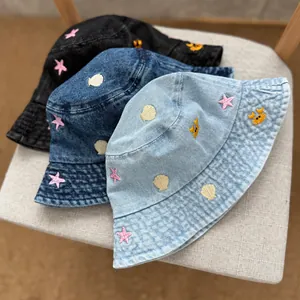 Detailed view of embroidered denim bucket hats featuring nautical shell and starfish patterns