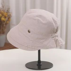 Detailed side view of a beige Japanese retro pleated bucket hat on a black display stand