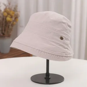 Detailed view of a vintage Japanese style beige pleated bucket hat on a black display stand