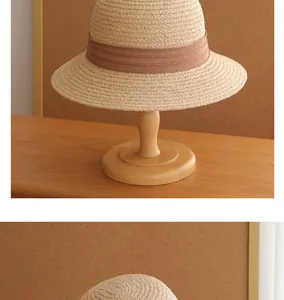 Close-up of a French vintage straw sun hat displayed on an elegant wooden stand.