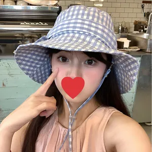 Blue and white gingham bucket hat with adjustable tie strap for summer sun protection.