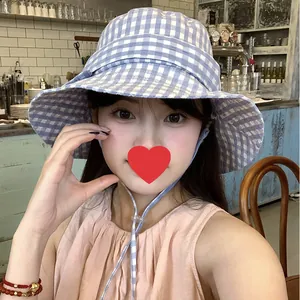 Blue and white gingham bucket hat with wide brim and adjustable chin strap for women.