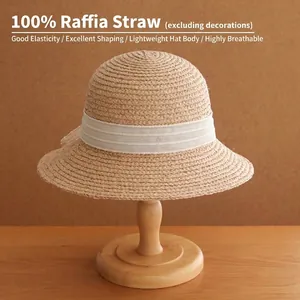 Elegant French retro 100% raffia straw woven sun hat with white ribbon on wooden stand