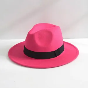 Dettaglio di un cappello fedora in feltro rosa con nastro nero classico.