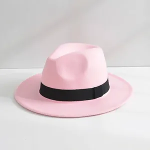 Dettaglio di un cappello fedora in feltro di lana rosa con un nastro nero classico ed elegante.