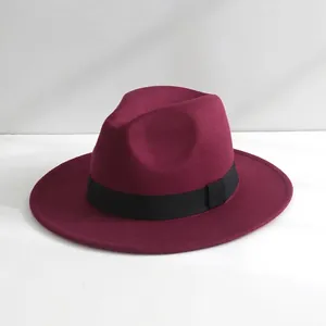 Primo piano della trama fine di un cappello fedora in feltro di lana bordeaux con nastro.
