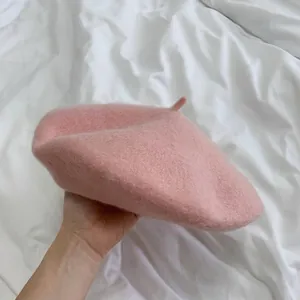 Detailed view of a soft baby pink wool beret hat, classic solid color painter cap