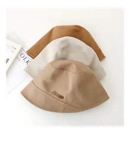 Dettaglio di tre cappelli a secchiello in cotone stile giapponese in beige e kaki