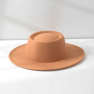 Detailed profile view of a vintage orange-brown wool felt hat with flat-top design