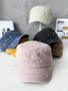 Close-up of distressed flat top military caps in multiple colors for sun protection