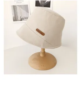Primo piano di un cappello da pescatore beige con etichetta in pelle fatta a mano