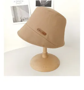 Dettaglio ravvicinato di un cappello pescatore giapponese kaki con toppa in cuoio artigianale.