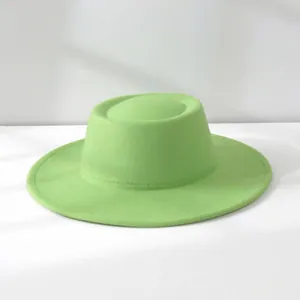 Detailed view showing the texture and shape of a vintage green wool felt fedora.